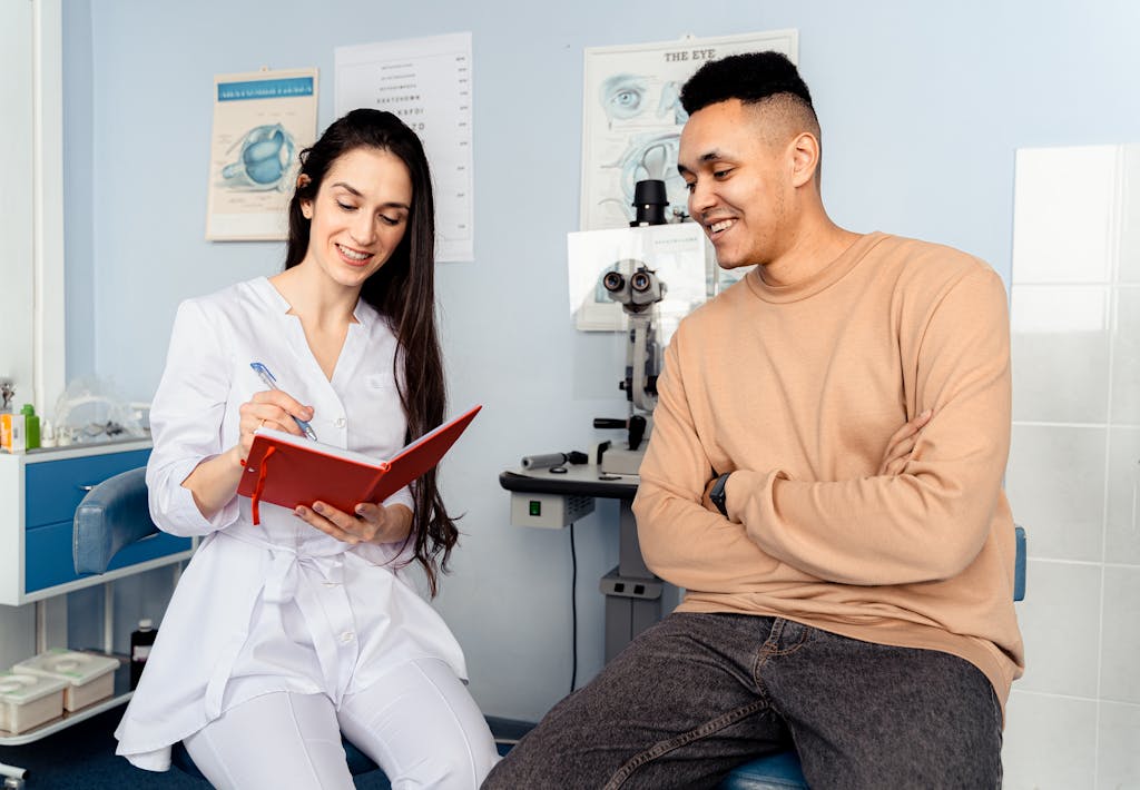 A male patient interacts with a female ophthalmologist in a clinic, showcasing a friendly consultation.