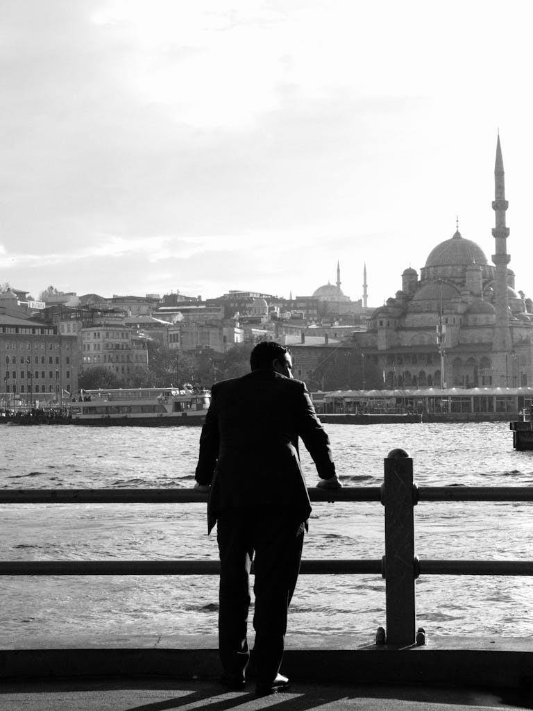 A man in silhouette overlooks the Istanbul skyline, featuring prominent mosque.