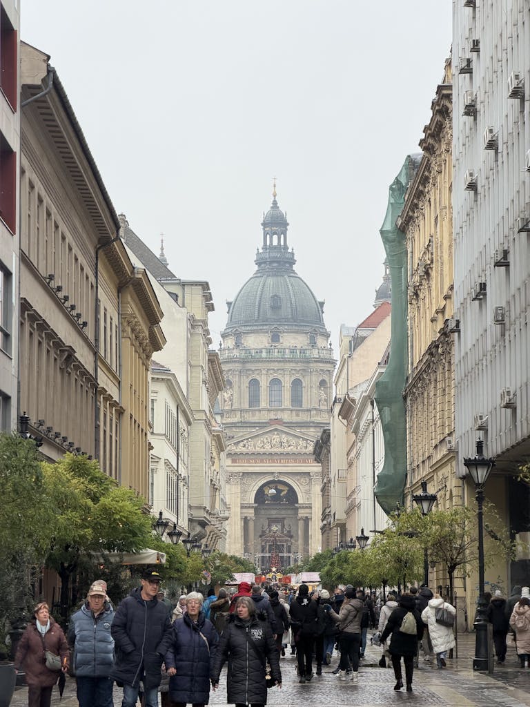Bustling street leading to iconic St. Stephen's Basilica in Budapest, capturing lively urban life and historic architecture.