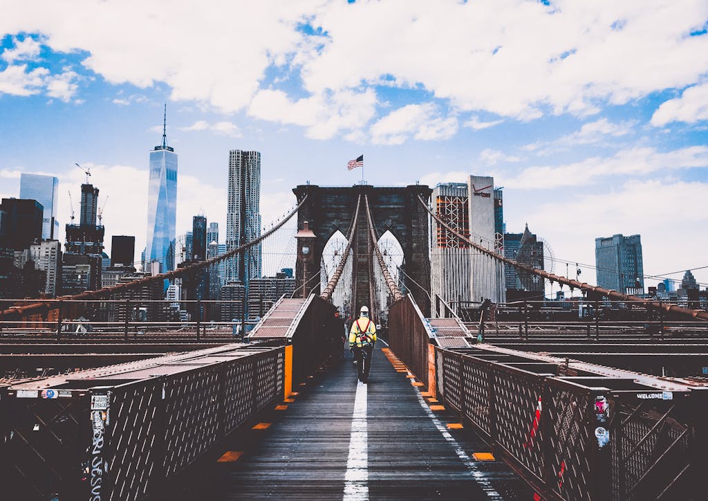 Iconic Brooklyn Bridge view with New York City skyline and construction worker.