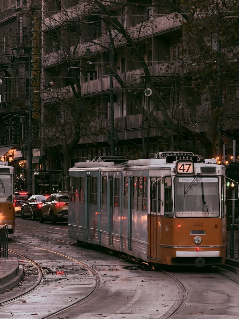 Iconic tram 47 navigates through the streets of Budapest during a moody dusk scene.