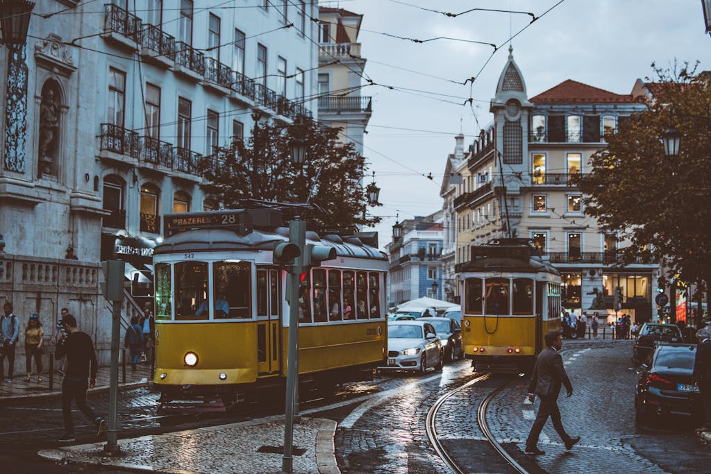 Scenic view of trams navigating the charming streets of Lisbon at dusk, capturing urban life and transportation.