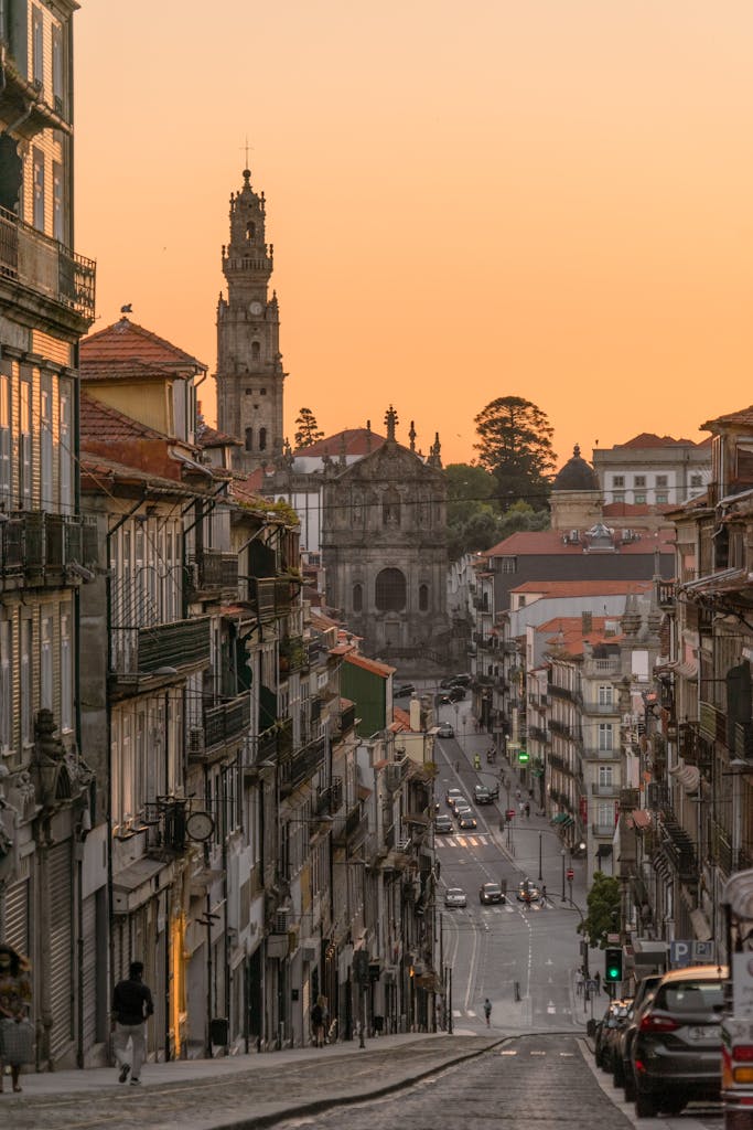 Stunning cityscape of Porto with Clérigos Church at sunset, capturing vibrant urban life and historic architecture.