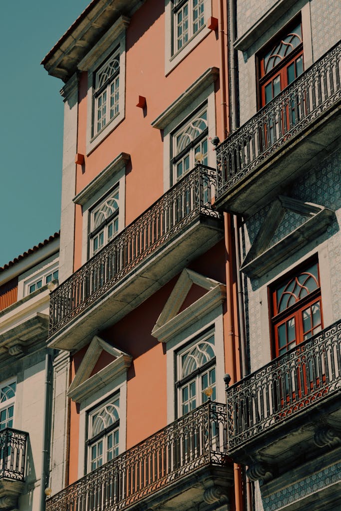 Sunny exterior of a classic 19th-century residential building in Porto, Portugal, featuring ornate balconies.