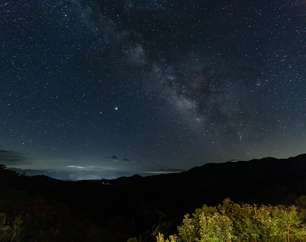 Starry night sky with Milky Way galaxy above the Smoky Mountains, showcasing nature's beauty.